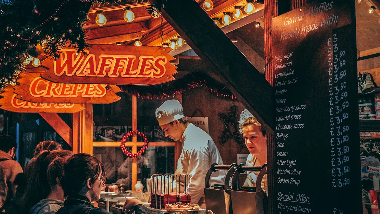 Serving customers from a wooden food stall at a Christmas market
