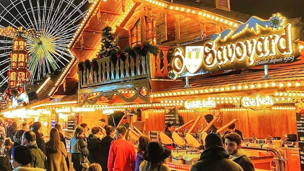 Christmas market food vendors with a ferris wheel in the background