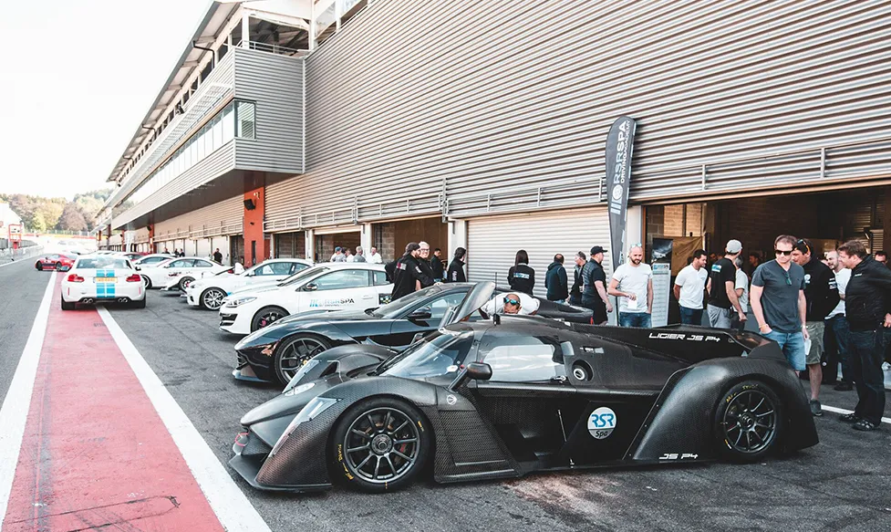 A Ligier racing car waits in the pit lane before taking to the race track