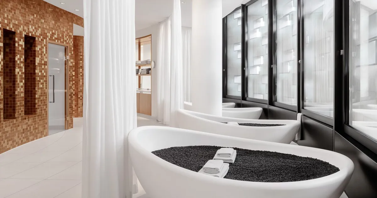 Curved white bathtubs are filled with black charcoal in a pristine room at The Dolder Grand Spa, Switzerland.