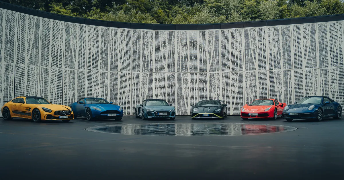 A selection of luxury supercars sits in a semi-circle on an Ultimate Driving Tours motoring experience.