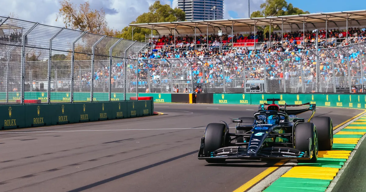 A Mercedes F1 car touches the apex of a corner exit in front of the fans in Melbourne
