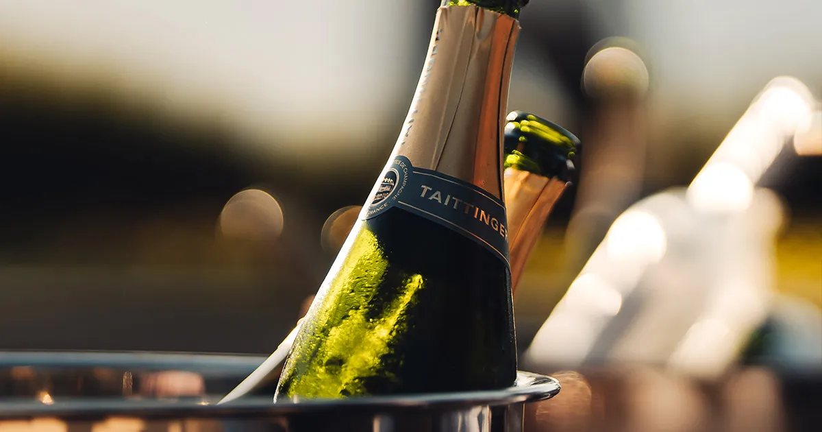 A close up of a bottle of Taittinger Champagne in an ice bucket.