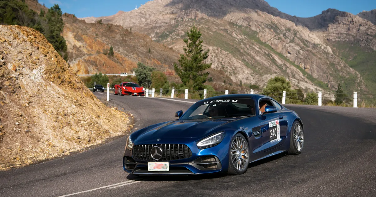 A blue Mercedes-Benz AMG GT sports car turns a corner on a rally in Tasmania.