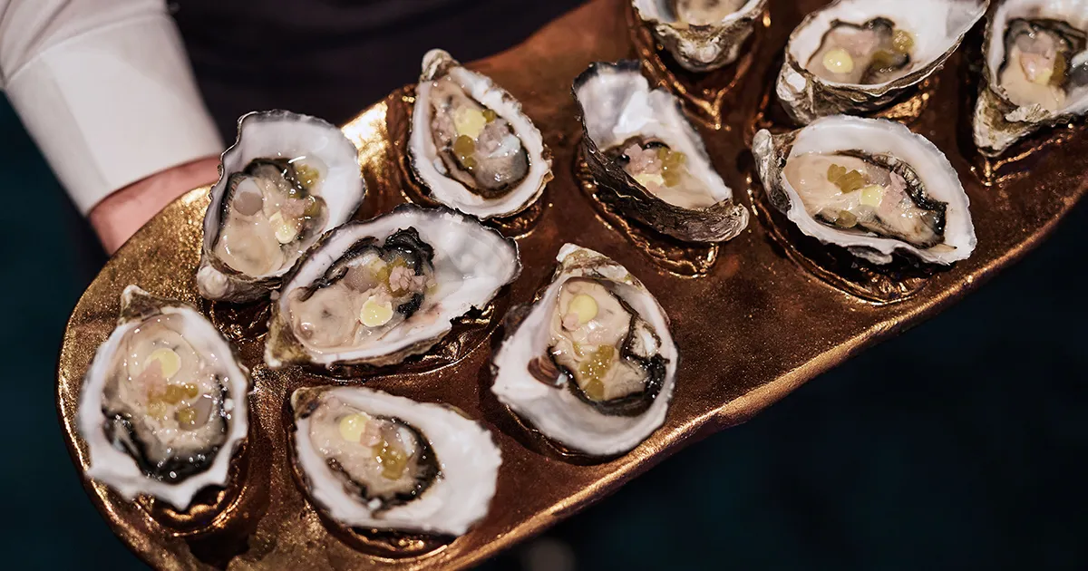 A waiter presents an elegant tray of Tasmanian oysters.