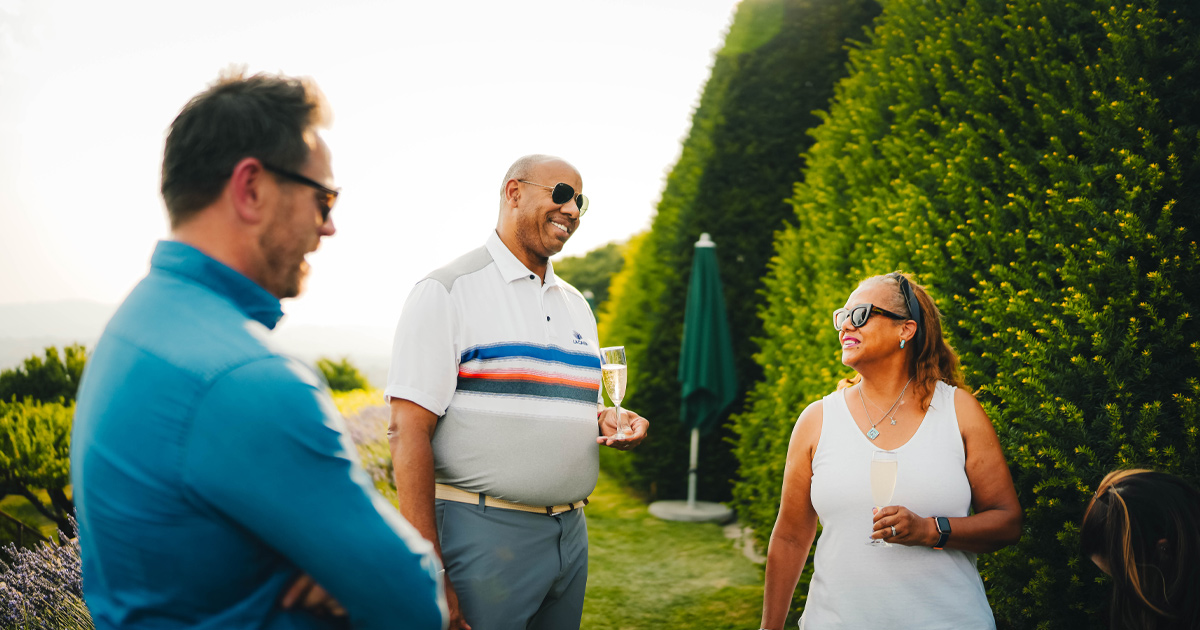 Two Ultimate Driving Tours guests enjoy a conversation with Anthony Moss in France