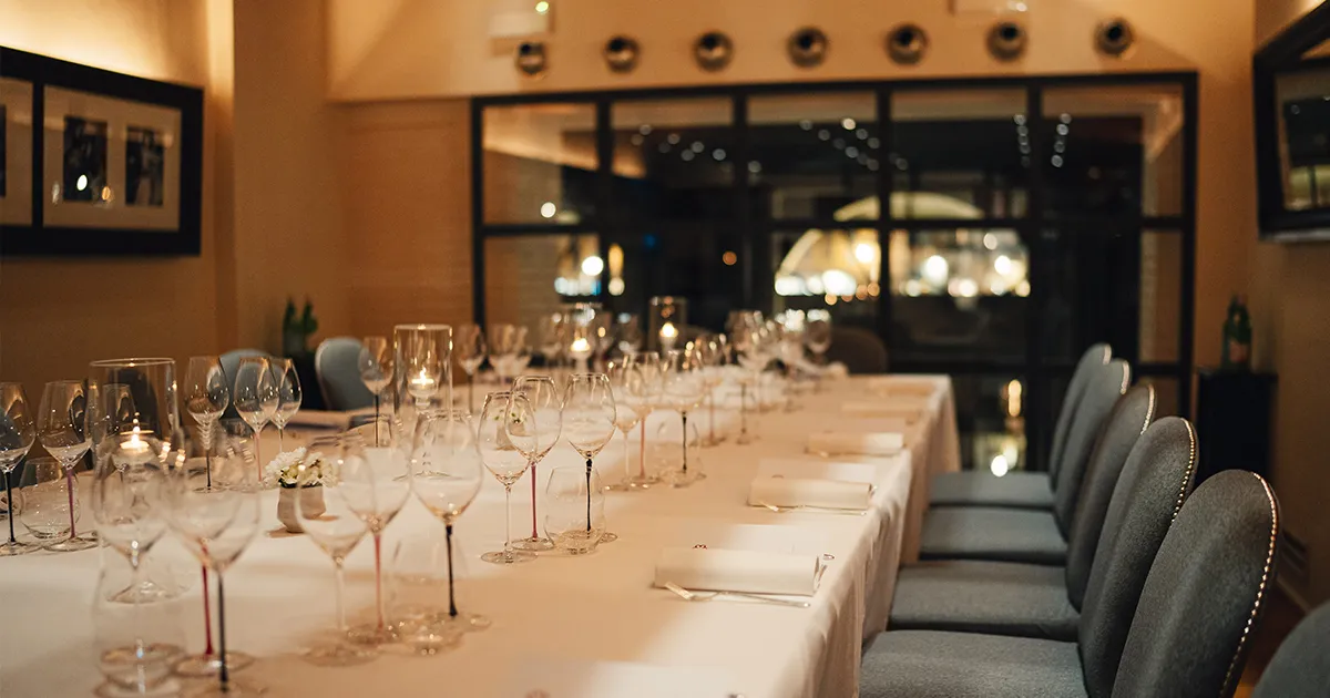 An immaculately lain white cloth table setting with a variety of wine glasses