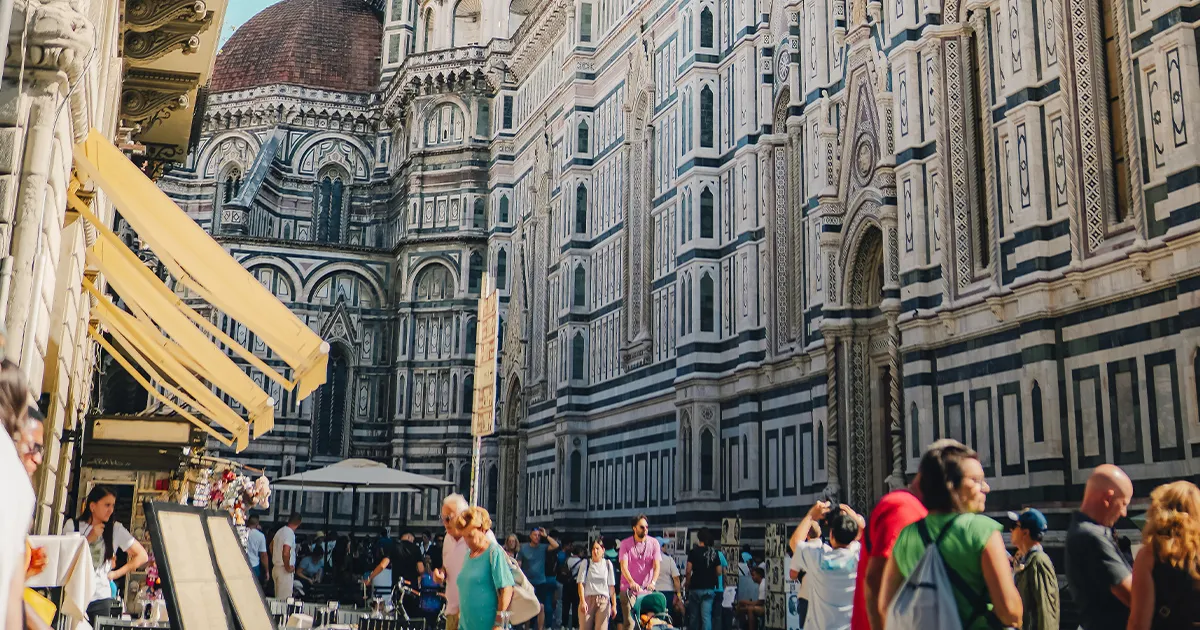 A majestic historical building towers over the busy streets of Florence
