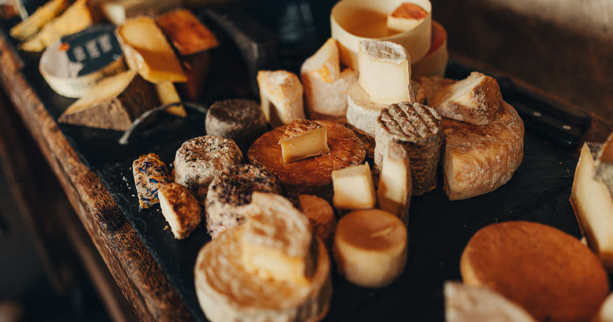 An artisan cheese board with a variety of soft and hard cheeses