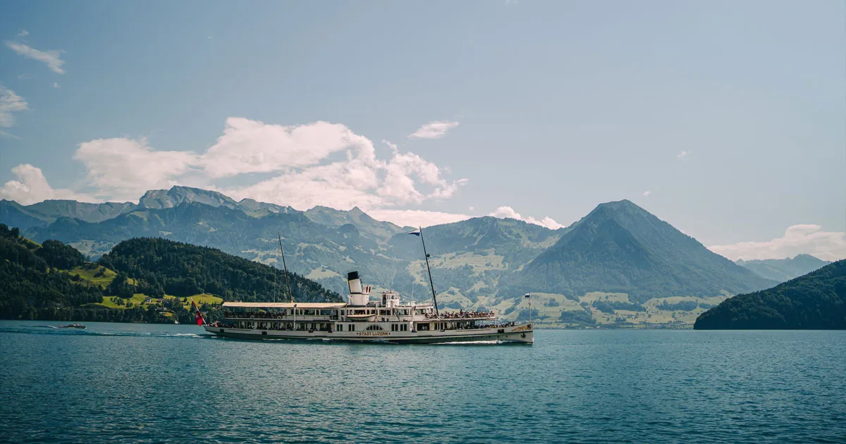 An old steamboat cruising leisurely along Lake Lucerne on a clear day