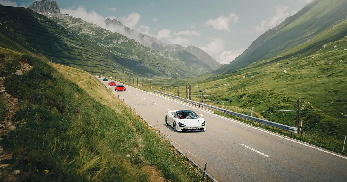 A convoy of Ultimate Driving Tours supercars led by a white McLaren 720S