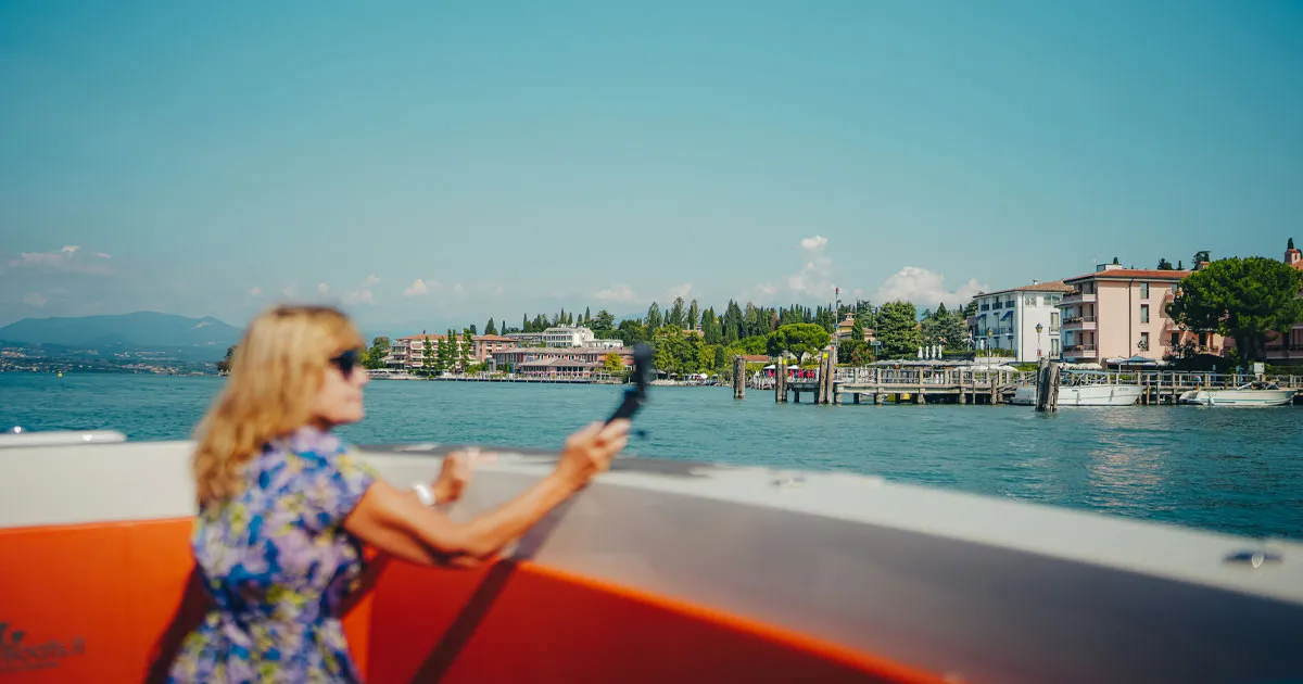 An Ultimate Driving Tours guest snaps a picture from a boat on Lake Garda
