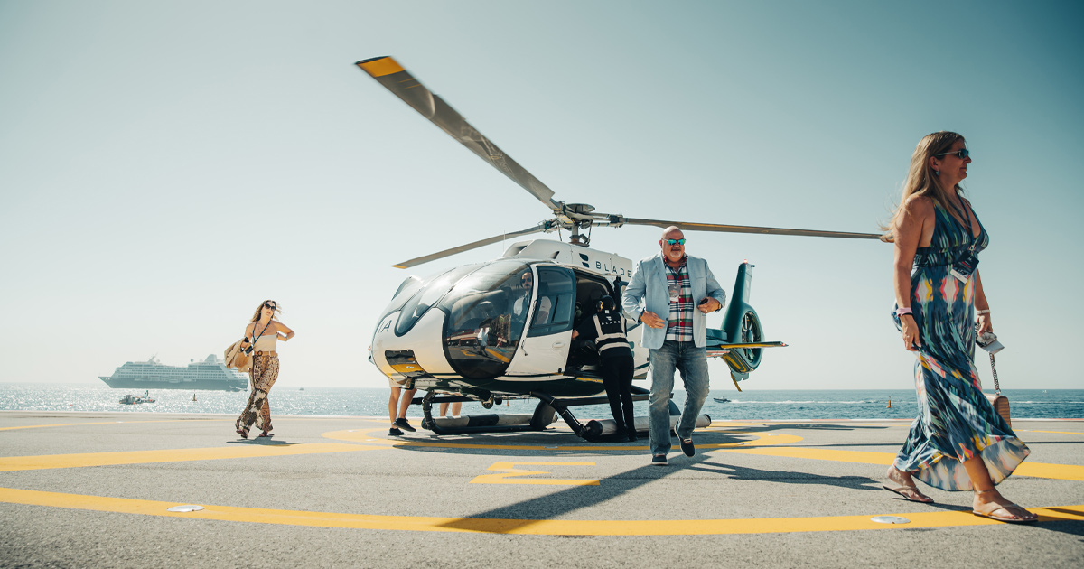 A man and two women walking away from a helicopter as part of a UDT luxury tour