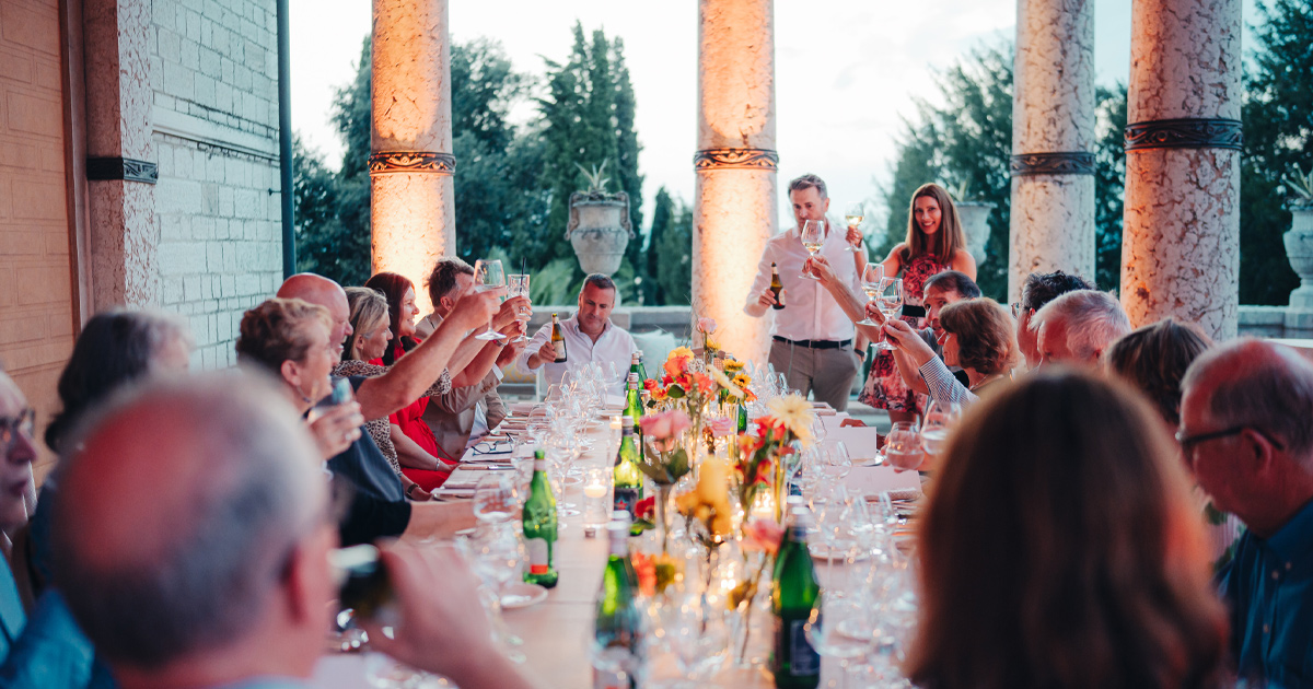 Ultimate Driving Tours guests share a toast at an elegant al fresco dinner table