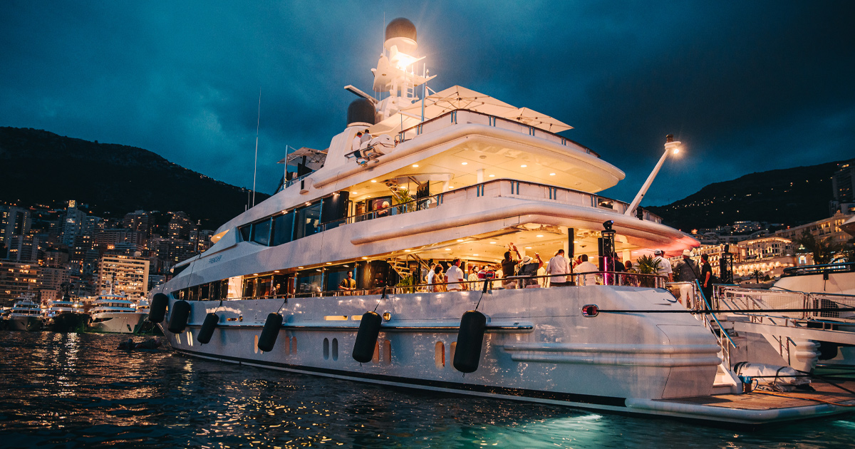 The Ultimate Driving Tours yacht is illuminated by night in Port Hercules, Monaco