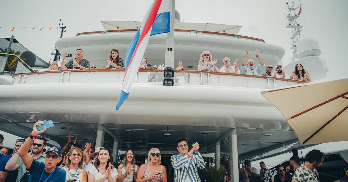 Happy guests cheering on the Ultimate Driving Tours yacht in Monaco