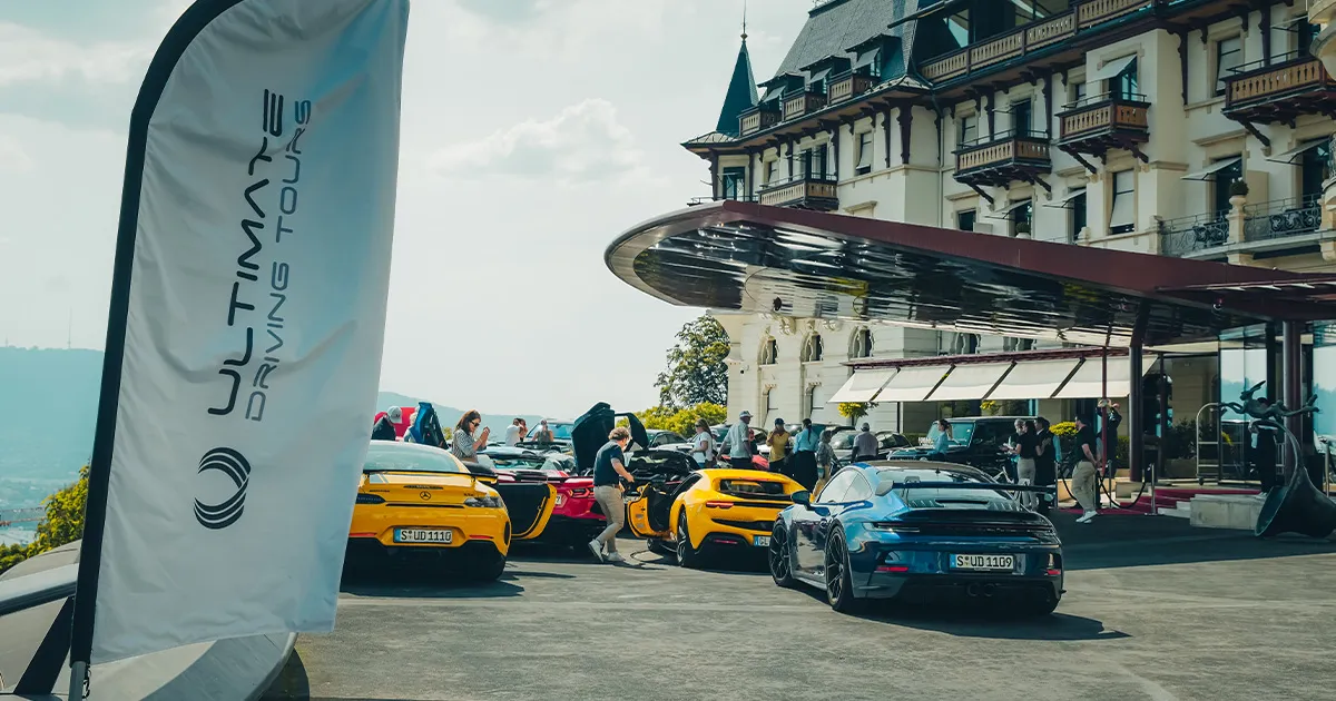 Ultimate Driving Tours’ fleet of supercars parked outside a luxury hotel.
