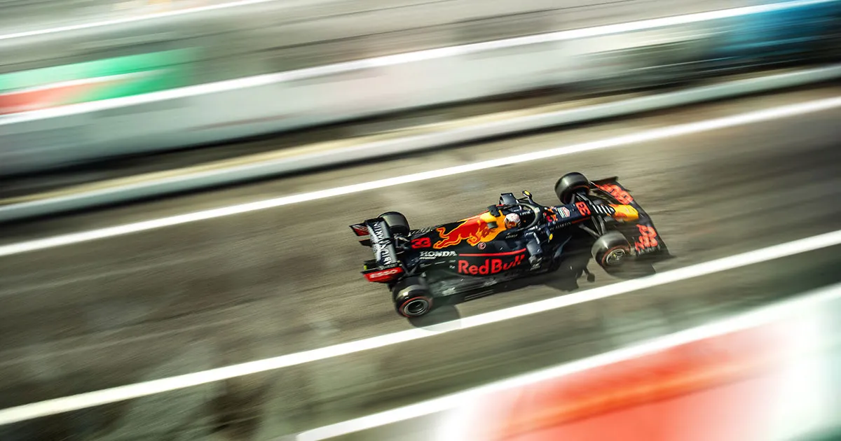 Max Verstappen’s Red Bull Racing F1 car racing along a straight with motion effect