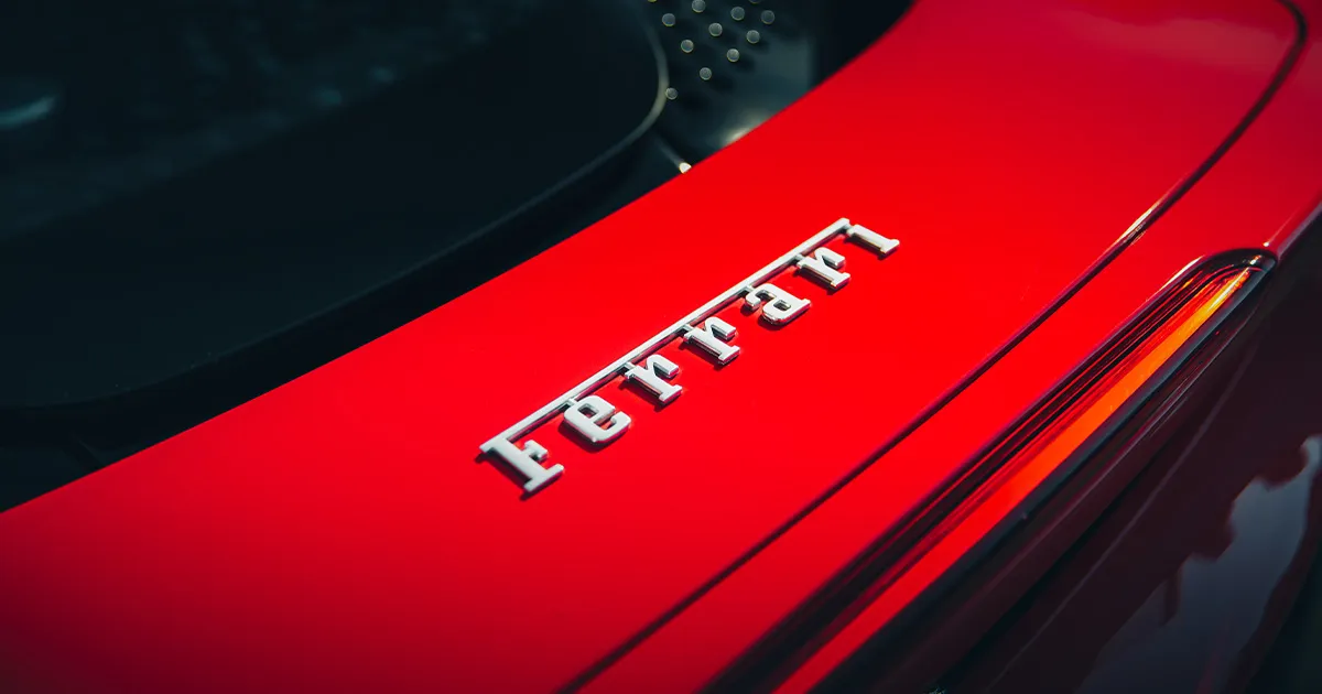 The Ferrari emblem on the rear of a red supercar.