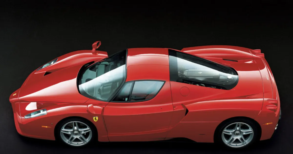 A red Ferrari Enzo supercar sitting in a studio environment.