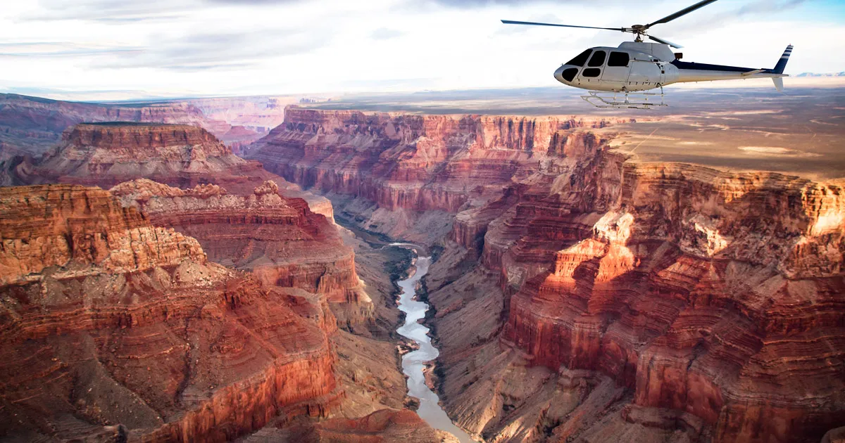 A helicopter flies above the Grand Canyon on a clear day.
