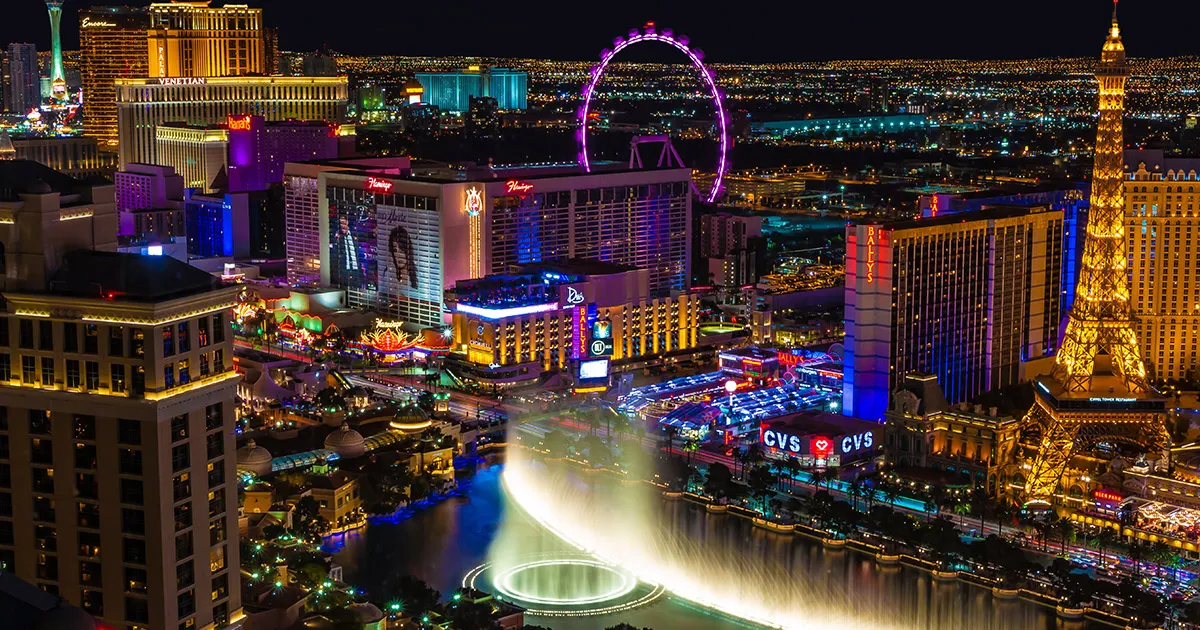 The casinos and fountains of Las Vegas at night glow with multicoloured neon lighting.