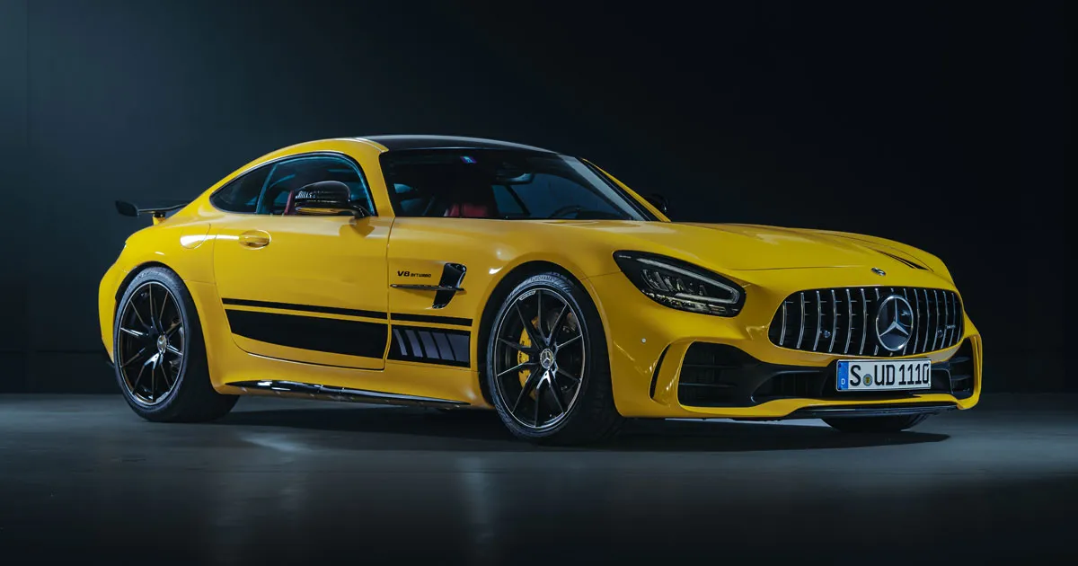 A yellow Mercedes-AMG GTR in a low-lit studio