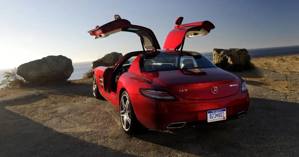 A red AMG SLS with signature gullwing doors raised aloft