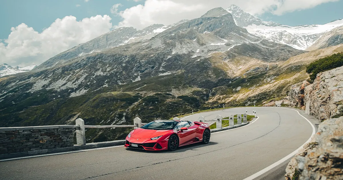 A red Lamborghini Huracán targa carves up an alpine road