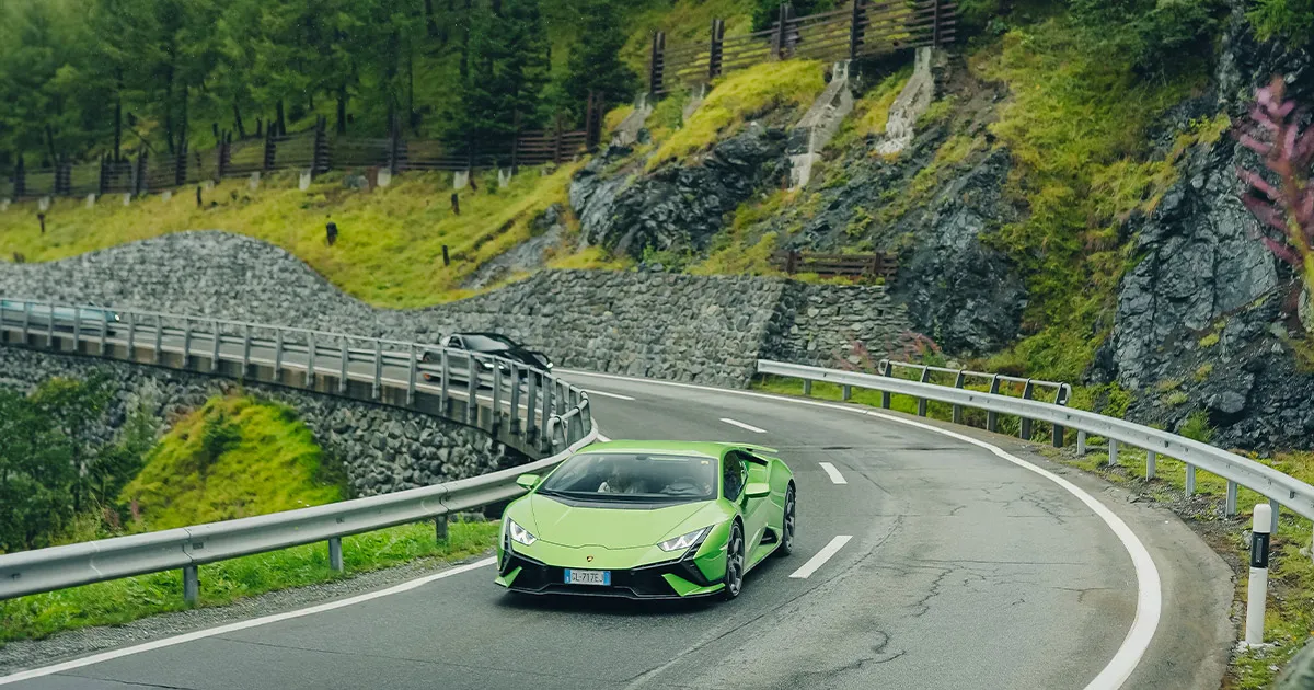A green Lamborgini Huracán carves up a sweeping corner on an Ultimate Driving Tours journey