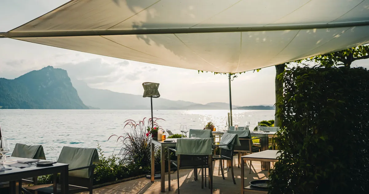 Panorama of an alpine lake with al fresco dinner setting