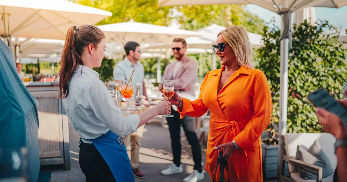 Fashionably dressed guests enjoying cocktails on an Ultimate Driving Tours tour.