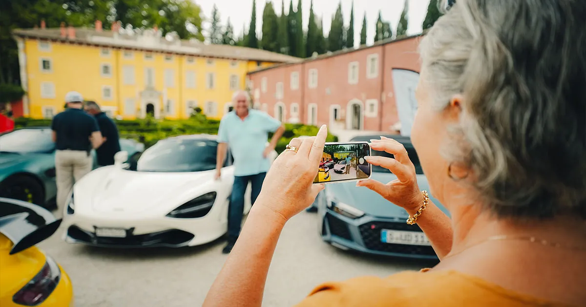 Ultimate Driving Tours guests pose for a photo in front of supercars.