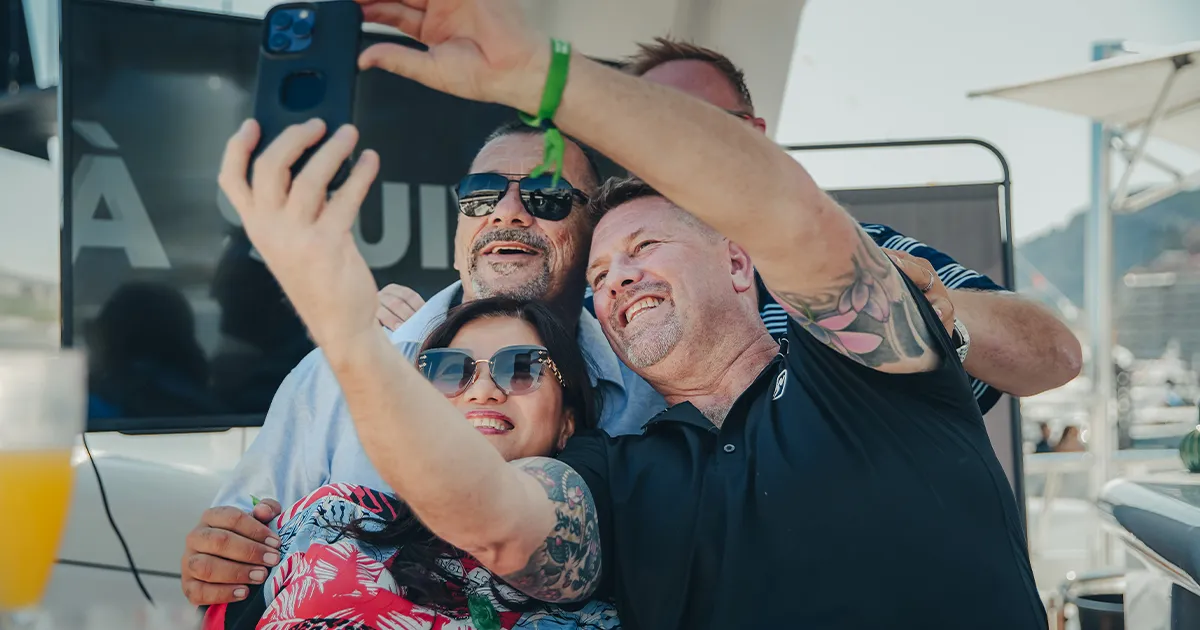 Two men and a woman snap a happy selfie on an Ultimate Driving Tours luxury tour.
