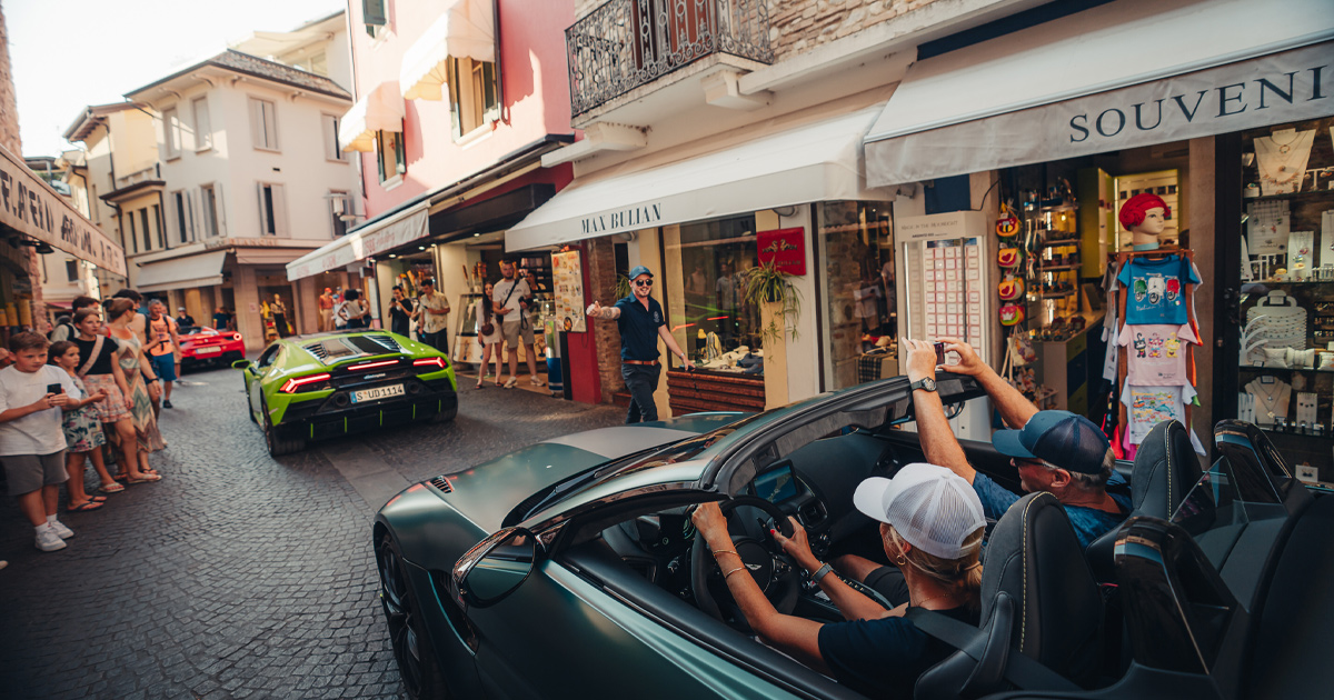 A green Lamborghinin Huracan and other supercars draw crowds on European backstreets