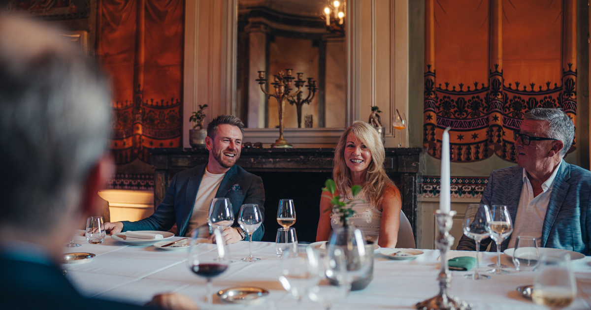Anthony Moss of Ultimate Driving Tours chatting with a small group at an elegant French restaurant