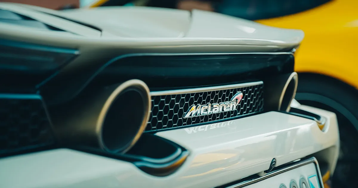 The rear grille with badge and twin exhaust tail pipes of a McLaren supercar 