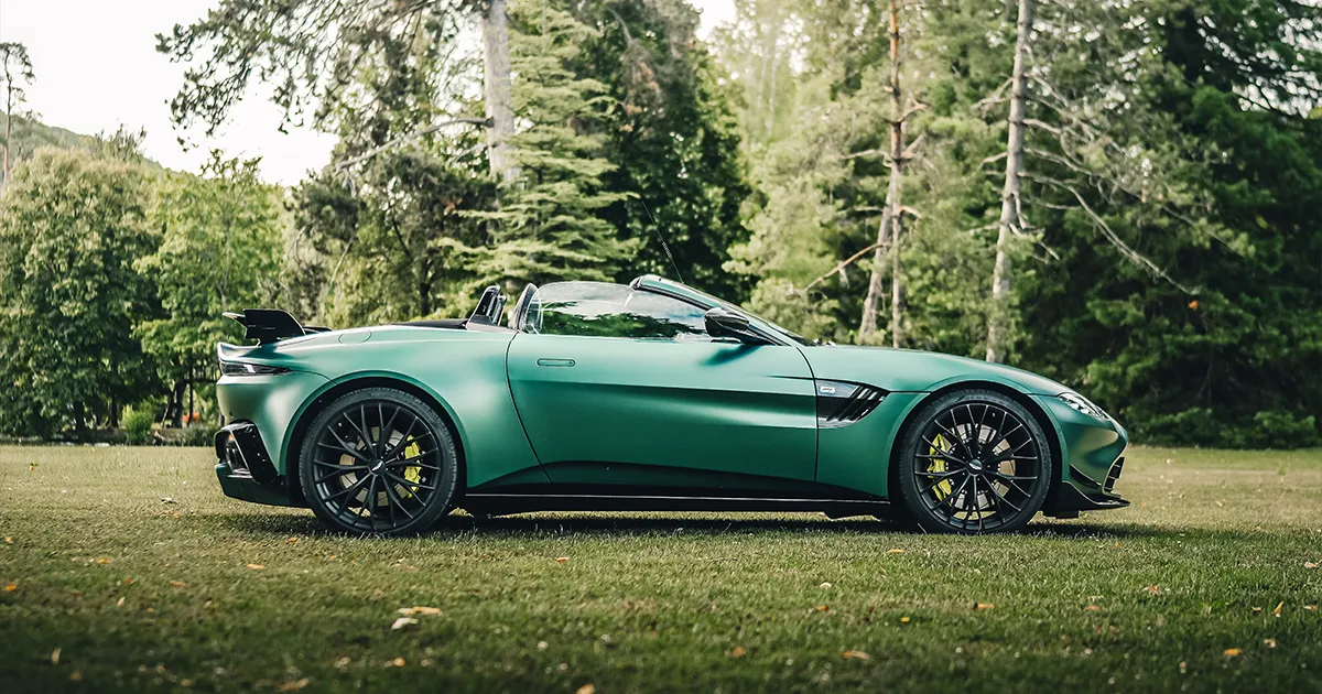 A green Aston Mantage Vantage F1 Roadster sitting on a grass lawn