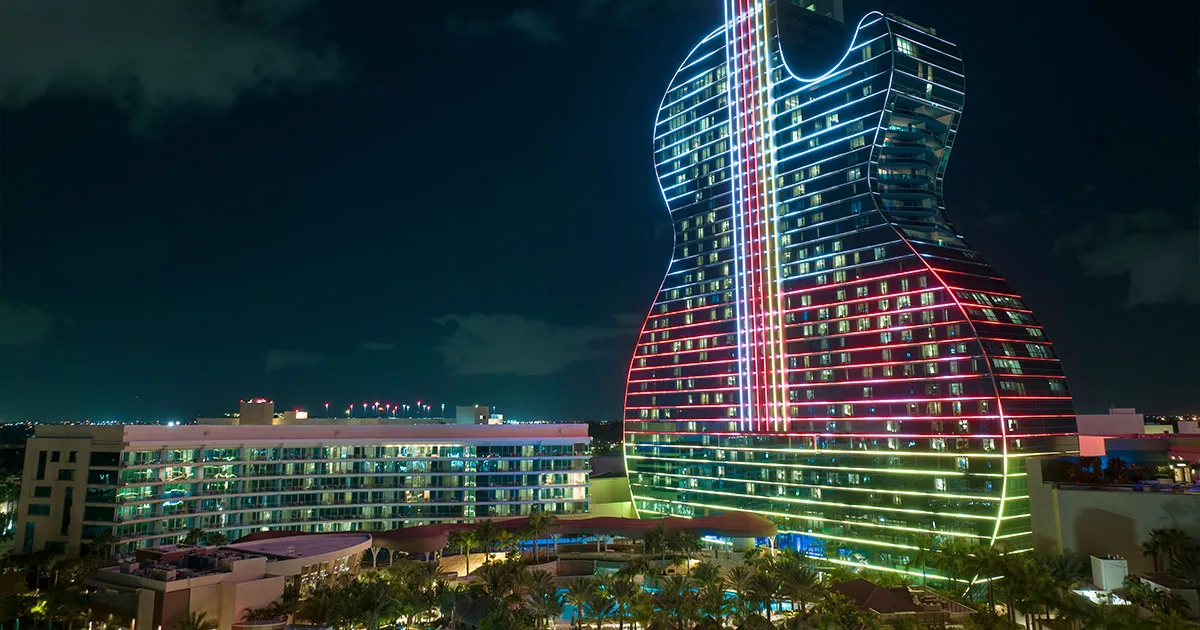 A neon lit multicoloured hotel in the shape of a guitar in Miami