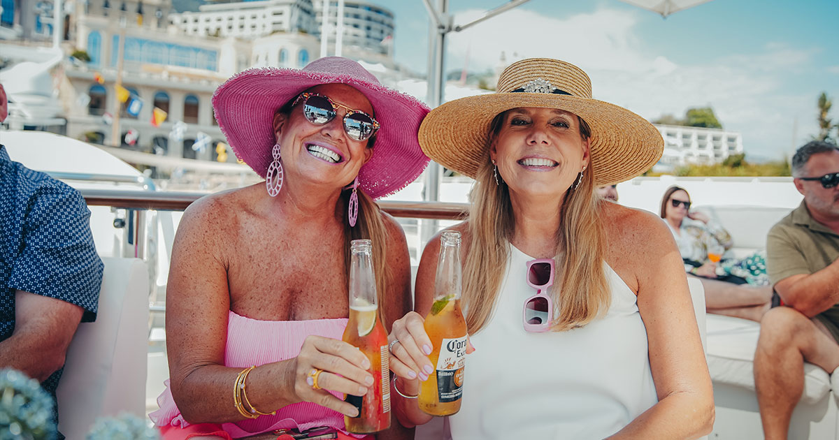 Two happy stylish ladies sharing a beer at the Grand Prix in Monaco