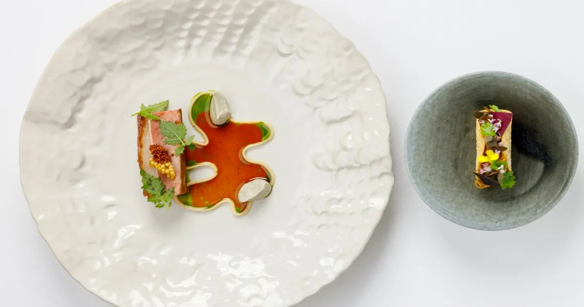 Artistically presented small plates of food with vibrant colours.