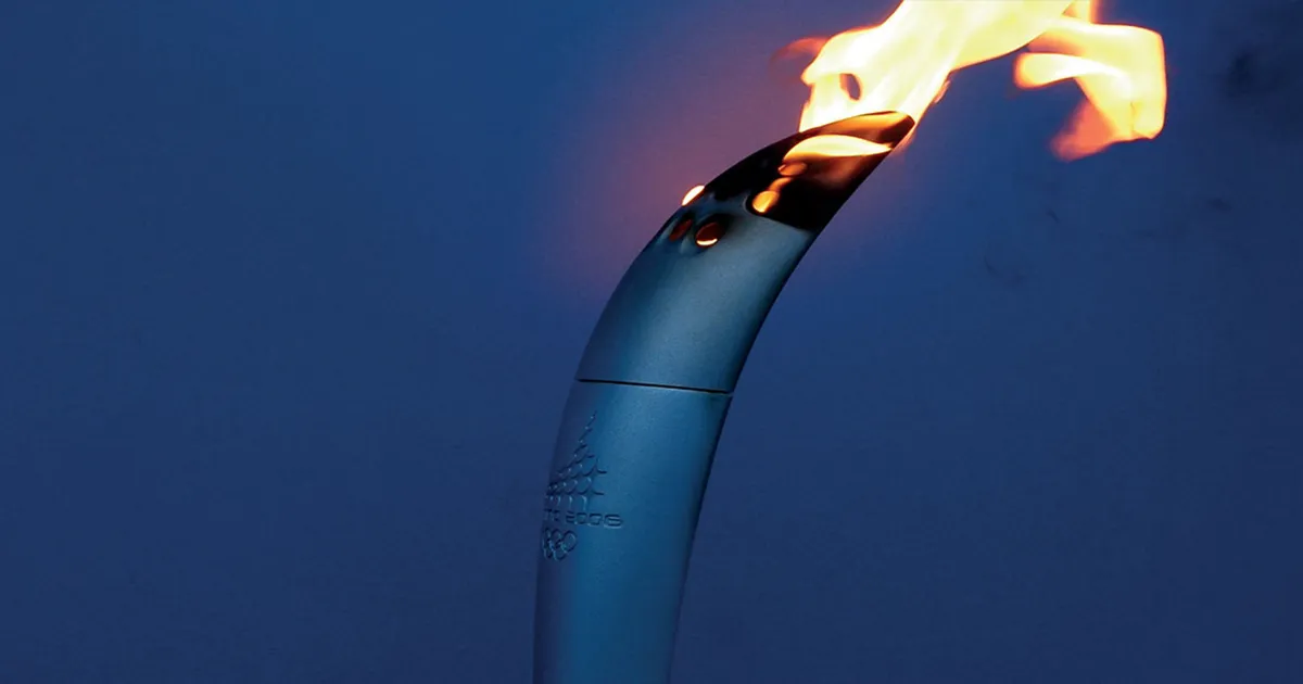 A sculpted metal torch etched with the words ‘Torina 2006’ emitting a flame from its top