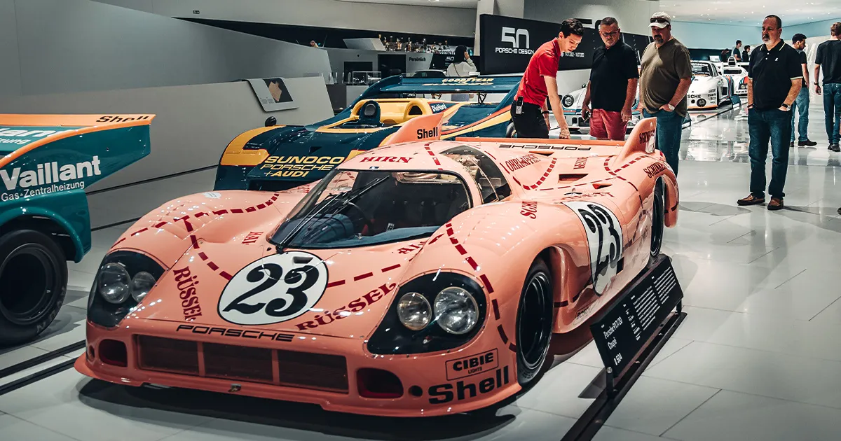 A pink Porsche 917/20 race car with sponsor livery, on display at the Porsche Museum, Stuttgart.