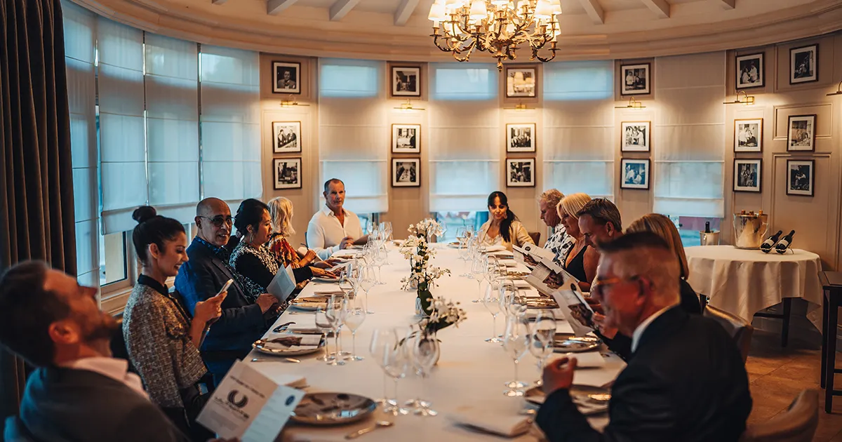 A group of guests sitting around a long dining table at Restaurant Paul Bocuse.