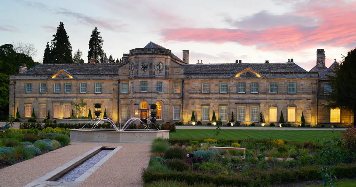 An exterior shot of Grantley Hall on a clear, red-sky evening.