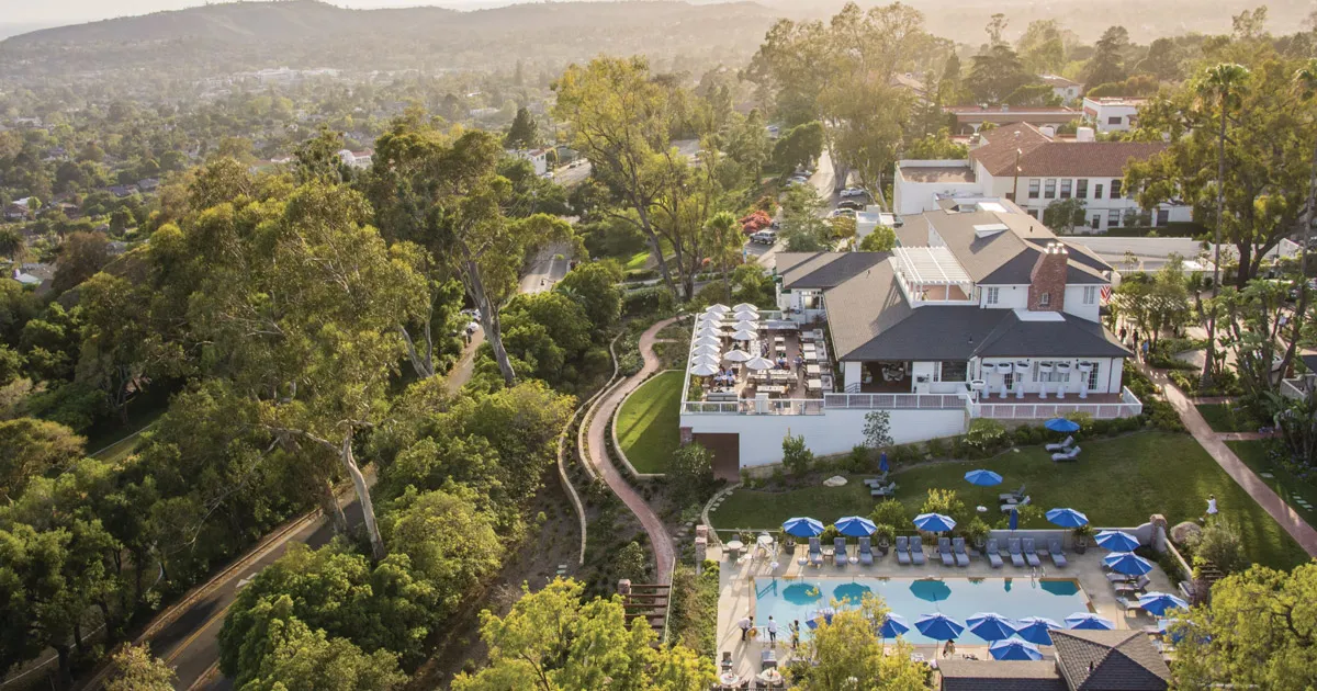 An elevated exterior shot of a large luxury hotel in the forested hills of California, the Belmond El Encanto.