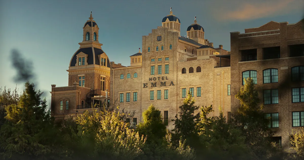 A huge brick building with arched windows and domed roof displays the marque ‘Hotel Emma’, San Antonio.