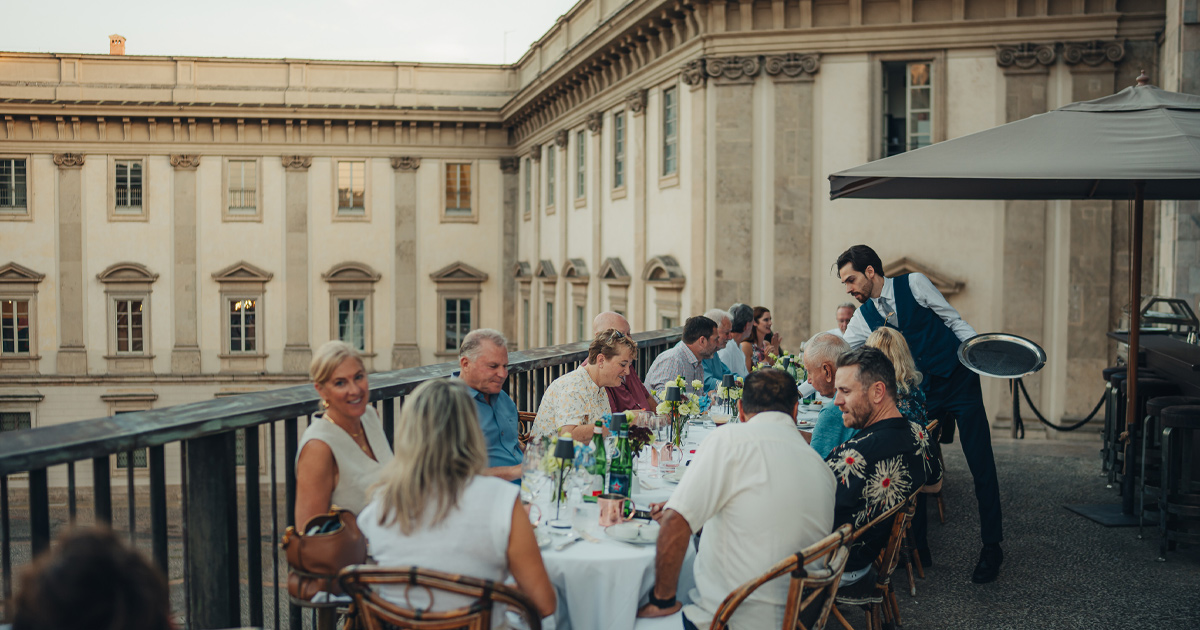 A waiter assists an Ultimate Driving Tours group in a Milanese restaurant