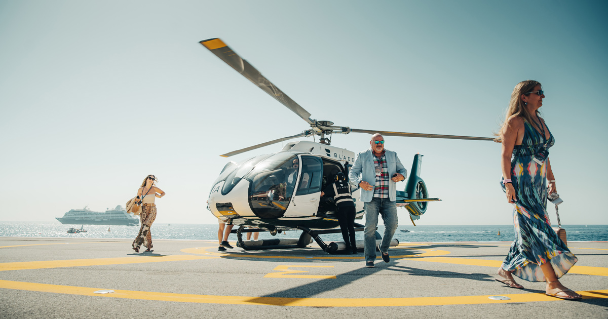 A small group disembarking from a helicopter on a sunny day as part of a UDT luxury tour
