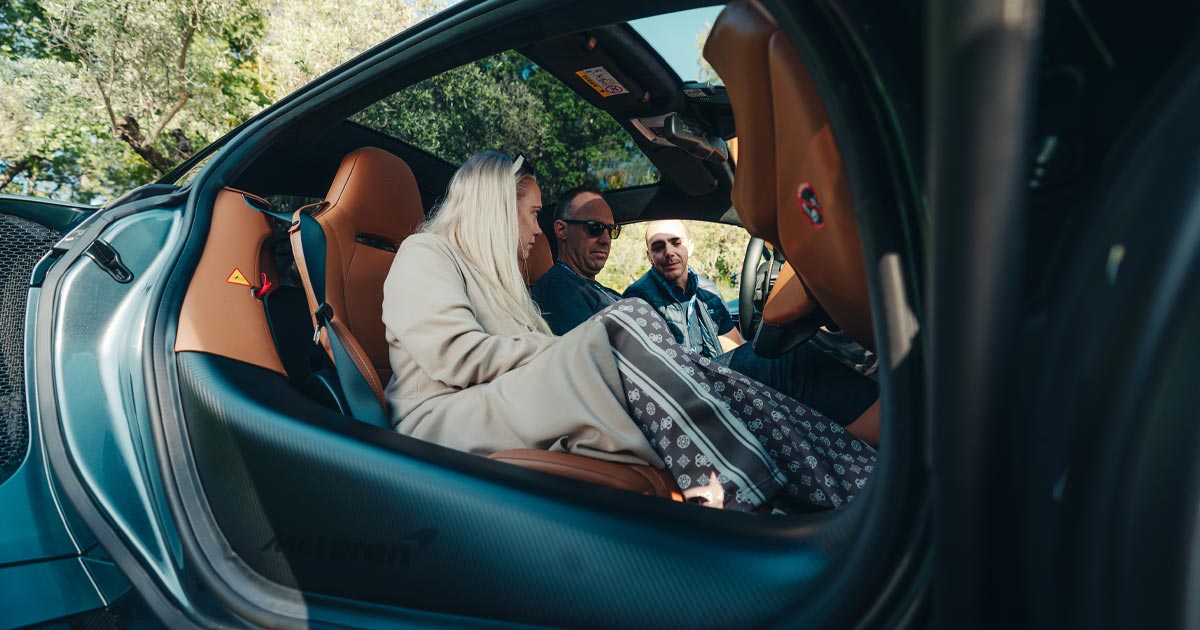 A couple are guided through a vehicle handover as part of an Ultimate Driving Tours self-drive tour